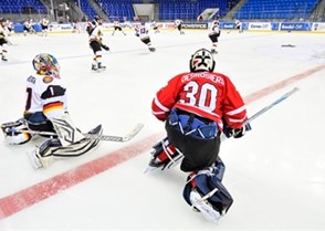SOCHI, RUSSIA - APRIL 20: Germany's Kevin Reich #1 and Canada's Philippe Desrosiers #30 stretch in the neutral zone in warm-up during preliminary round action at the 2013 IIHF Ice Hockey U18 World Championship. (Photo by Matthew Murnaghan/HHOF-IIHF Images)